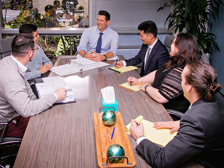 The firm's staff smiling and talking in a conference room